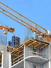 Beschleunigter Wohnungsbau Es werden Häuserblöcke mithilfe von Kränen gebaut.
