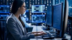 Frau kontrolliert Prozesse an Computerbildschirmen