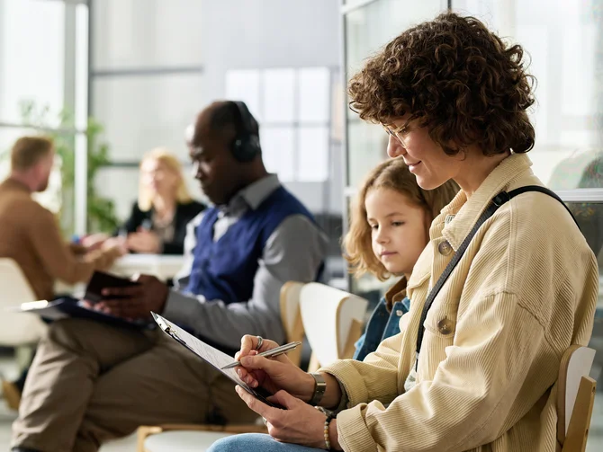 migration-asyl-und-auslaenderrecht-c-mediaphotos-adobestock Frau mit Kind und Klemmbrett in Wartebereich einer Beratungseinrichtung