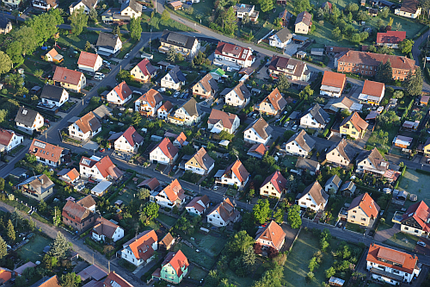 Luftbildaufnahme einer Siedlung mit Einfamilienhäusern aus den 1950er Jahren.