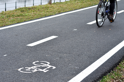 Foto von Fahrrad auf einem Radschnellweg entlang eines Flusses.