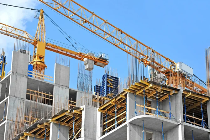 Beschleunigter Wohnungsbau Es werden Häuserblöcke mithilfe von Kränen gebaut.