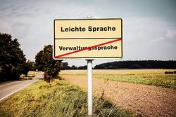 Foto: Straßenschild "Einfache Sprache" und durchgestrichen: "Verwaltungssprache"Sign Easy versus Difficult