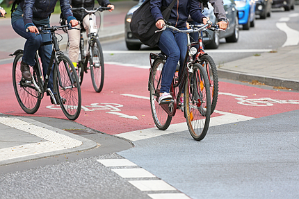 Radfahrer auf vier Fahrräder fahren auf einem Fahrradweg.