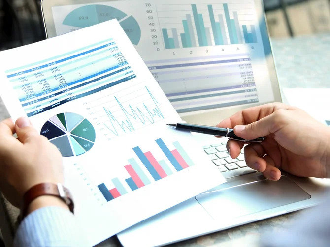 kommunale-finanzen-und-abgaben-c-saklakova-adobestock Detailansicht einer Finanzauswertung mit Kreisdiagramm, Balkendiagramm und Zahlentabellen neben Laptop