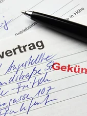 Kündigung eines Mietvertrags Ein Mietvertrag, der mit einem Stempel mit der Aufschrift „Gekündigt“ versehen ist. Oben rechts liegt ein Kugelschreiber.
