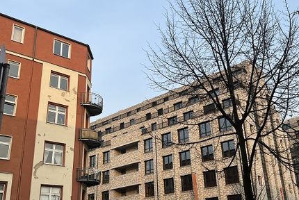 Ein altes Haus mit bröckelnder Fassade neben einem hochwertigen Neubau in Berlin sind zeigen die fortschreitender Gentrifizierung.