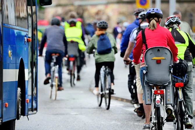 Radverkehr und öffentlicher Nahverkehr Links ist ein Bus zu sehen. Rechts vom Bus sowie vor dem Bus sind viele Radfahrer zu erkennen.