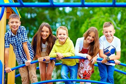 Lachende Kinder auf einem Spielplatzgerüst