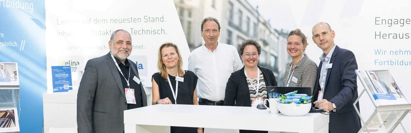 Messe KOMMUNAL Erfurt Kolleginnen und Kollegen des vhw stehen freundlich lächelnd an ihrem Messestand.