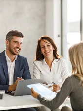 Zertifikatslehrgang Fachkraft Kommunales und öffentliches Personalmanagement Drei Personen lächeln eine junge Frau an, während sie sich unterhalten.
