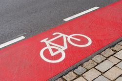 Foto: Roter Fahrradstreifen auf einer Straße mit Radsymbol