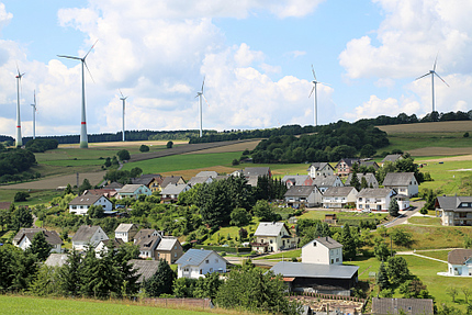 Foto: Windkraftanlagen in der Nähe einer Wohnsiedlung.