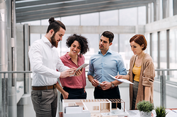 Architektenteam bespricht sich am Tisch mit einem Gebäudemodell