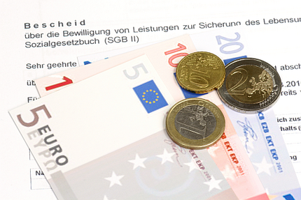 Auf einem Antrag auf Sozialleistungen liegt Geld