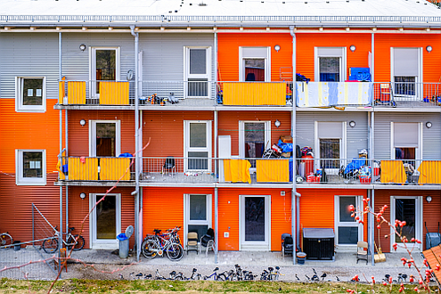 Bunte Fassade einer Flüchtlingsunterkunft mit Balkonen in Containerbauweise.