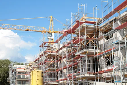 Eine Baustelle an einem Wohngebäude mit sichtbaren Bauarbeiten und Gerüsten.