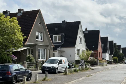 Einfamilienhaussiedlung mit Statteldächern und Vorgärten in norddeutscher Wohnstraße