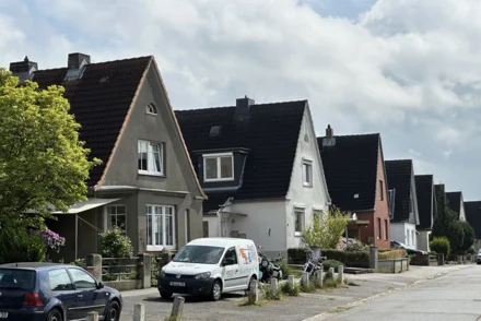 Einfamilienhaussiedlung mit Statteldächern und Vorgärten in norddeutscher Wohnstraße