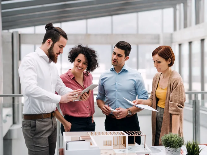 Architektenteam bespricht sich zu einem Gebäudemodell.