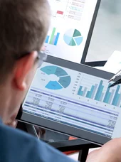 fachkraft-kostenrechnung-controlling-und-berichtswesen-im-kommunalen-rechnungswesen-c-saklakova-adobestock Hand zeigt mit Stift auf Tablet-Diagramme bei Auswertung von Finanzkennzahlen und Tabellen