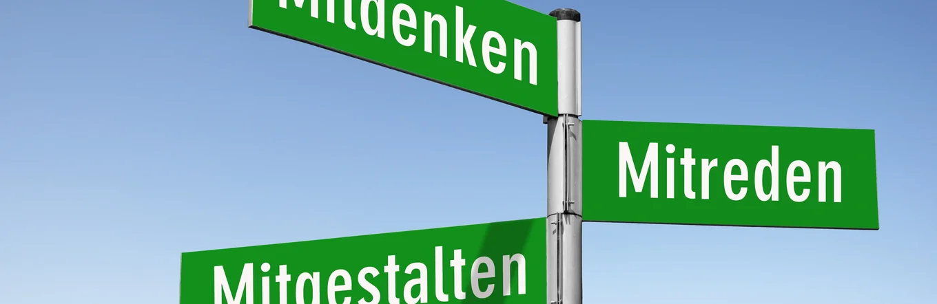 Straßenschild mit drei grünen Schildern: Mitdenken, Mitreden, Mitgestalten.