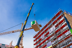 Foto eines Baukrans vor dem Rohbau eines öffentlichen Gebäudes