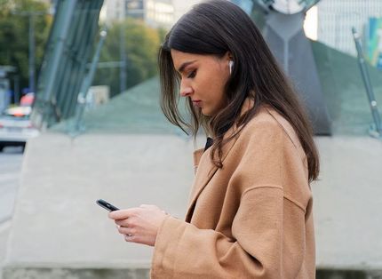 Junge Frau schaut auf ihr Smartphone