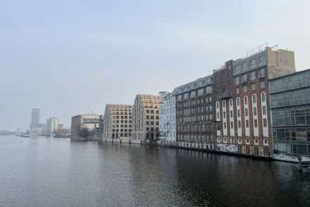 Berliner Spreeufer mit heterogener Bebauung aus Gründerzeit, Industriebauten und Neubauten bei bedecktem Himmel