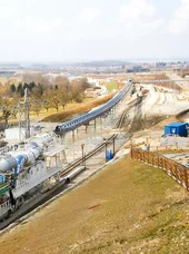 Planfeststellung von Infrastrukturprojekten Industrielle Landschaft, umgeben von Wiesen und Bäumen.