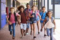 Kindergerechte Planung symbolisiert durch ein Foto lachender Schulkinder in einem Schulgebäude