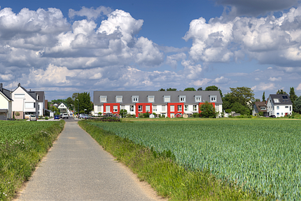 Neubausiedlung neben landwirtschaftlichen Flächen