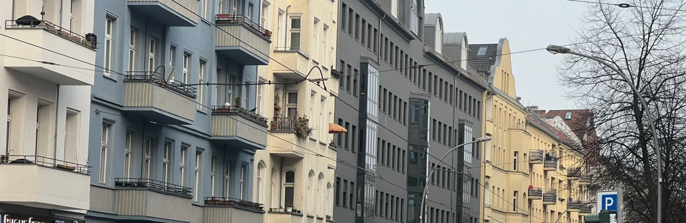 Innerstädtische Berliner Straße mit Altbauten, Kleingewerbe und Fußgängern an Wintertag