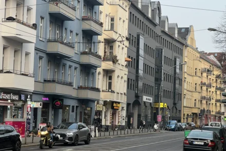 Innerstädtische Berliner Straße mit Altbauten, Kleingewerbe und Fußgängern an Wintertag