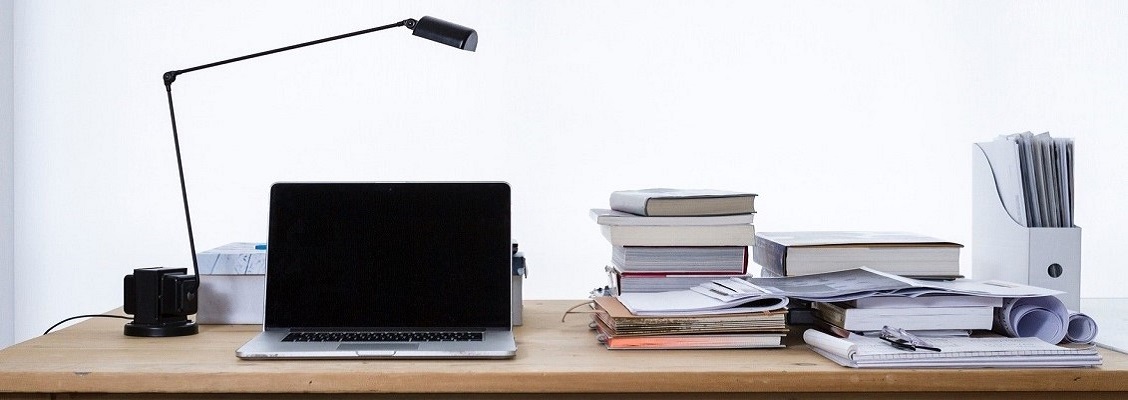 Fotos eines Schreibtisches mit einem Laptop und Büchern