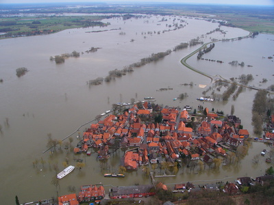 Luftbild von Fluss mit starkem Hochwasser und von Wasser eingeschlossene Häuser