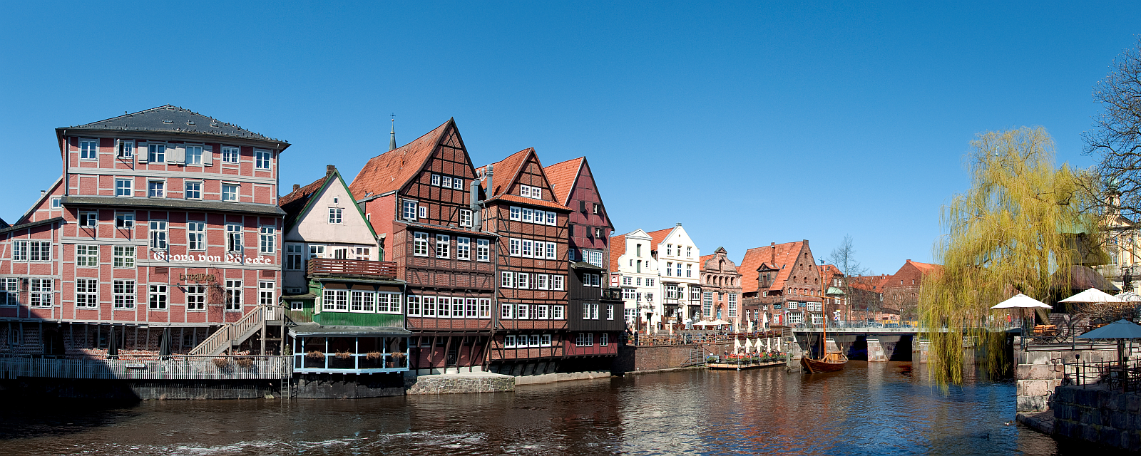Panorama-Ansicht der Lüneburger Altstadt mit dem Fluss Ilmenau im Vordergrund.