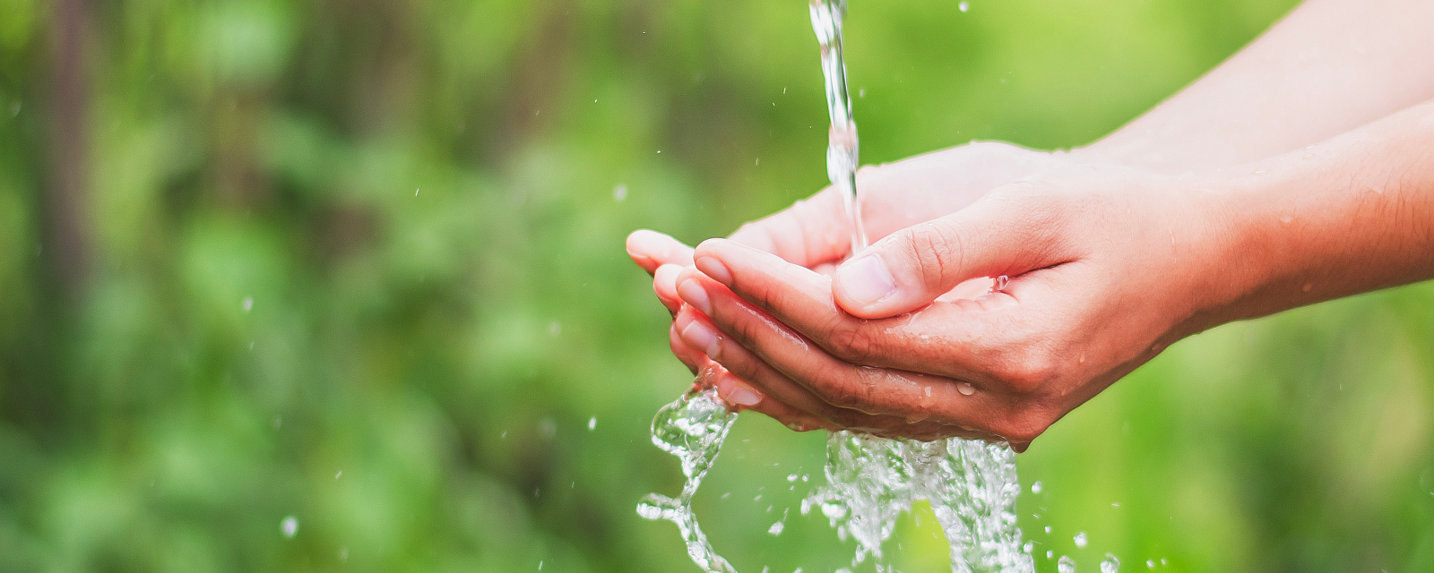 Foto: Zusammengeführte Hände fangen einen Wasserstrahl auf