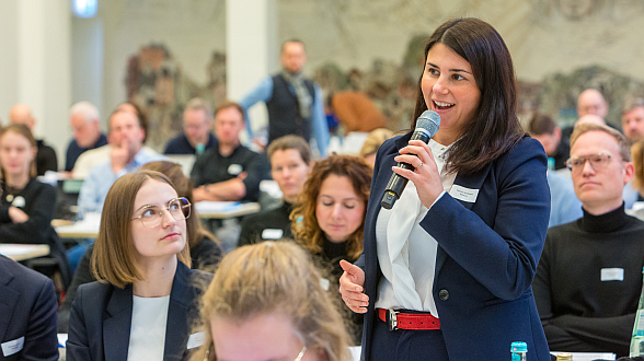Teilnehmerin beteiligt sich über einen Redebeitrag auf einer vhw-Bundesrichtertagung