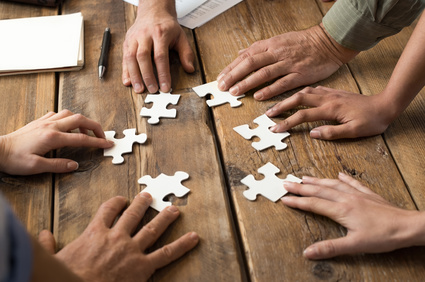 Mehrere Menschen arbeiten an einem Puzzle 